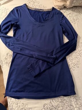 This is a Nike Pro navy blue long-sleeve V-neck athletic top.